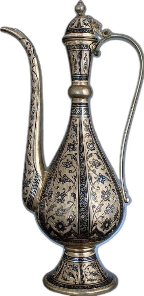 An ornate silver ewer inlaid with niello botanical scrollwork, slender spout and arched handle, photographed as a catalogue study on a pale ground.